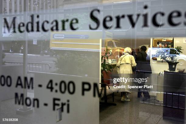 Two people walk inside a Medicare Services office on the last day for enrollment in the Medicare Part D program May 15, 2006 in New York City....