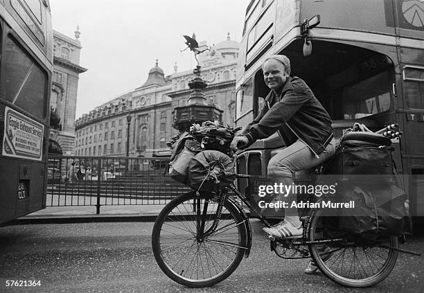 German round-the-world cyclist Heinz Stucke passes a London bus in Piccadilly Circus during his travels, 1977.