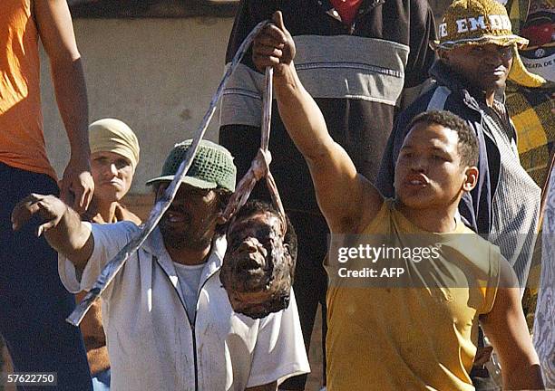 Rebellious inmates of the Campo Grande Maximal Security Penitentiary in Matto Grosso do Sul, Brazil, show 15 May, 2006 the severed head of inmate...