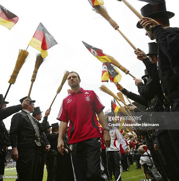 Jens Nowotny of Germany walks through a line of chimney sweepers after the test match between FSV Luckenwalde and the German National Team at the...