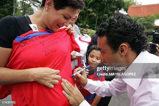 El jugador de la seleccion nacional de Costa Rica, Michel Rodriguez, firma una camiseta de la seleccion a una aficionada el 16 de mayo de 2006 en un...