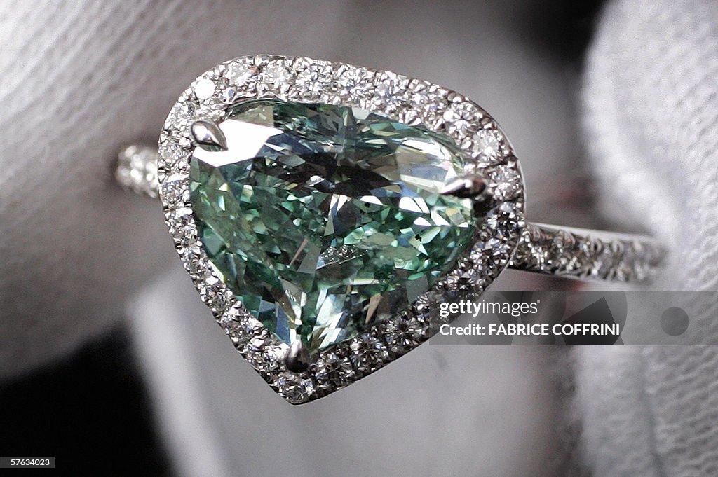 A heart-shaped blue-green diamond weighi