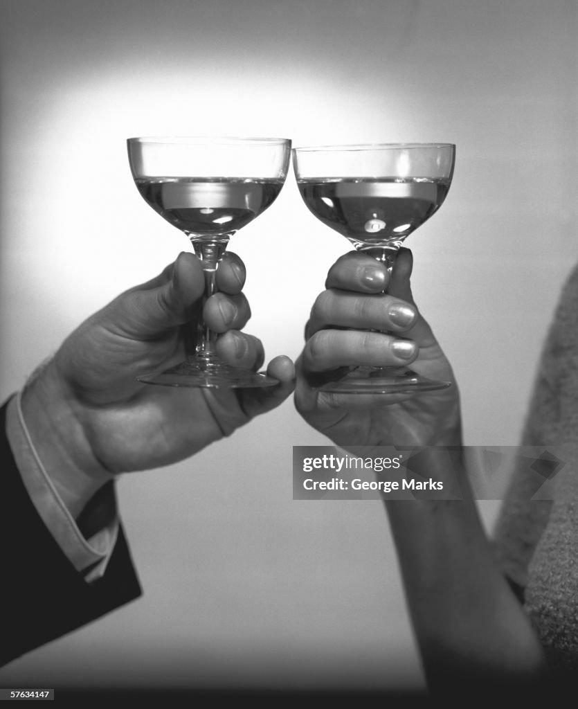 Couple toasying with white wine, (Close-up of hands), (B&W)