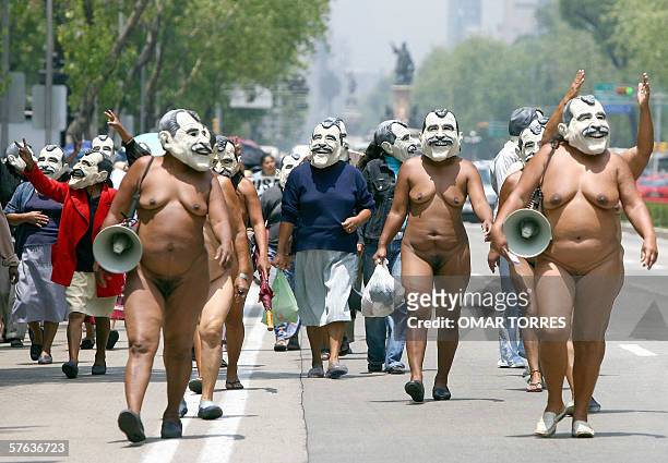 Woman of the indigenous group "400 Pueblos" with masks of Mexican president Vicente Fox, march along Reforma Avenue in Mexico City 17 May 2006,...