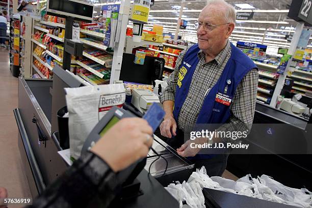 Clayton Fackler works at the check out at the new 2,000 square foot Wal-Mart Supercenter store May 17, 2006 in Bowling Green, Ohio. The new store,...