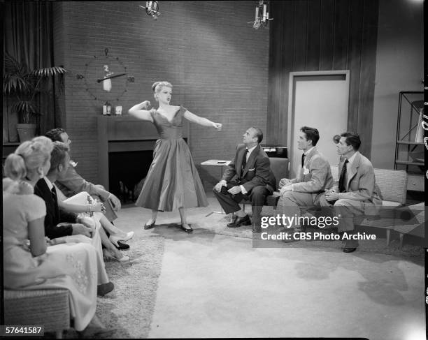 American actress Angela Lansbury stands and acts out charades on the 'Pantomime Quiz' game show featuring show regulars Jackie Coogan , John...