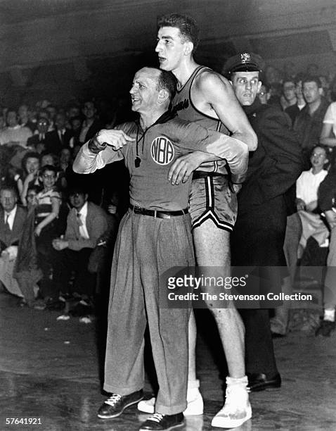 Dolph Schayes of the Syracuse Nationals stands with the referee during a game played n 1955 in Syracuse, New York. NOTE TO USER: User expressly...