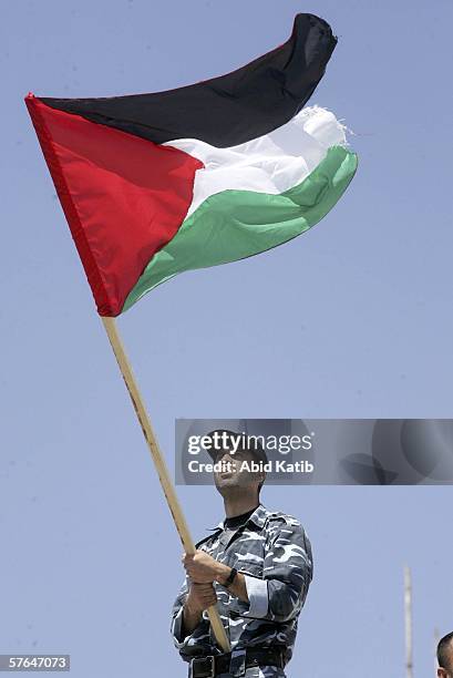 Holding the national flag, a Palestinian member of the security forces rallys in support of the Hamas-led government May 18, 2006 in Gaza City, Gaza...