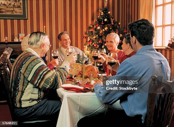 family toasting wine at christmas meal - thanksgiving golf foto e immagini stock