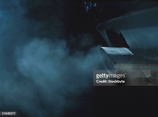a exhaust pipe of a car emitting fumes - car fumes stock-fotos und bilder