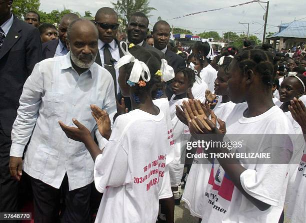 Port-au-Prince, HAITI: New Haitian President Rene Preval talks with students during a ceremony marking Haitian Flag Day 18 May 2006 in the Arcahaie...