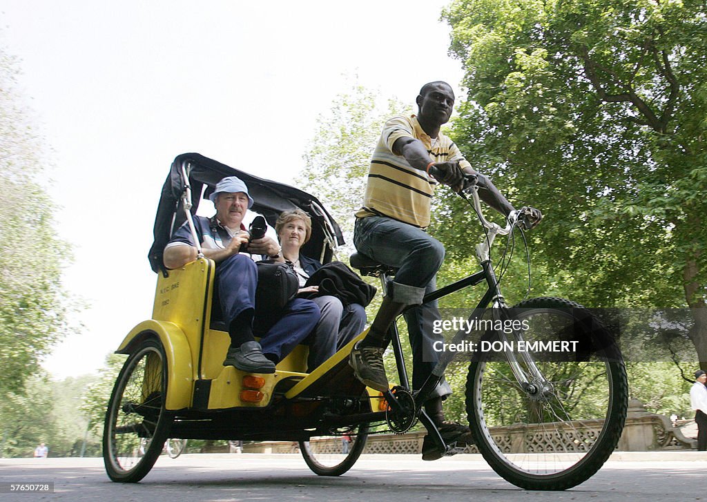 A pedicab rider takes tourists on a ride