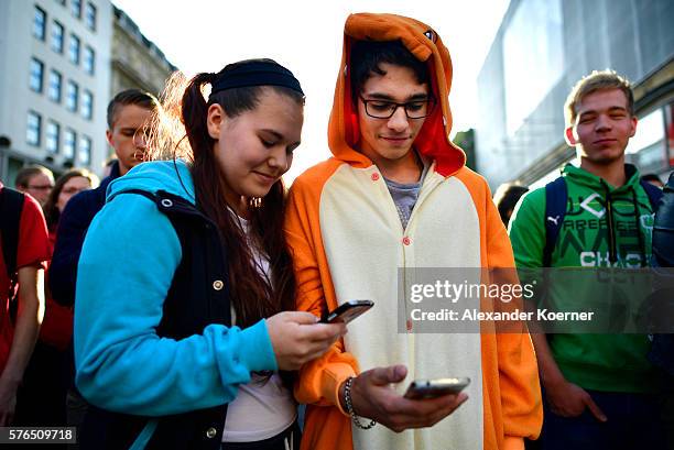 Young players walk through the city centre of Hanover while holding their smartphones and playing "Pokemon Go" on July 15, 2016 in Hanover, Germany....