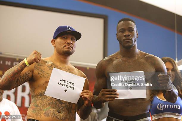 Chris Arreola and WBC World Heavyweight Champion Deontay Wilder pose with "His Life Matters" signs during their weigh-in at Legacy Arena at the BJCC...