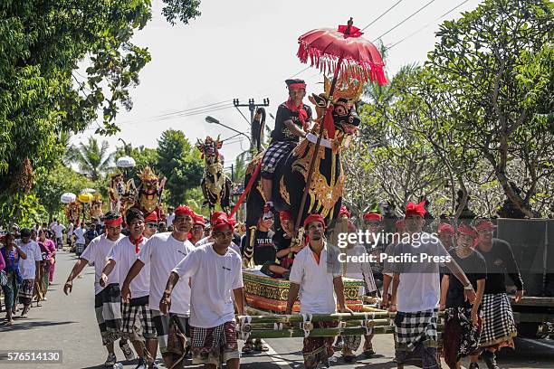 Balinese carries a sarcophagus in the form of mythical buffalo during a mass Balinese Hindu cremation ritual called 'Ngaben' at a cemetery of Batuan...