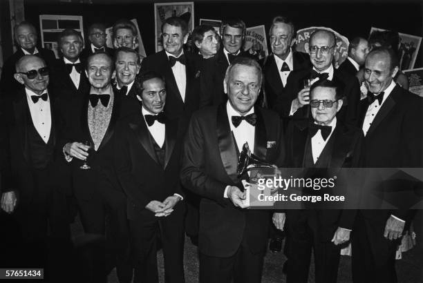 Singer Frank Sinatra holds a Grammy Awards as he is honored by celebrity friends Paul Anka, Glenn Ford, Phil Harris, Rich Little, Red Skelton, Julie...