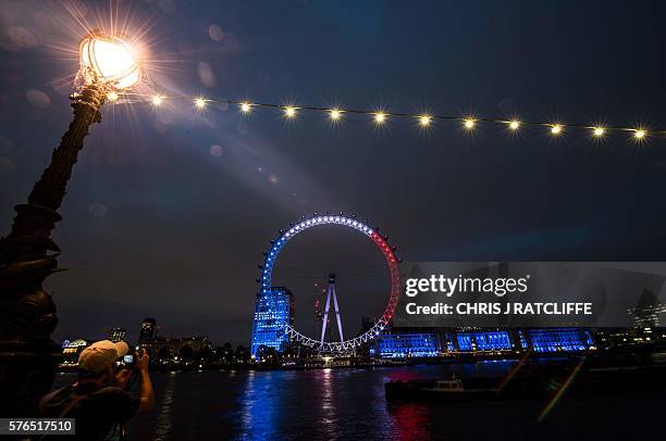 London landmark, The London Eye is illuminated in blue, white and red lights, resembling the colours of the French tricolour flag on July 15 as...