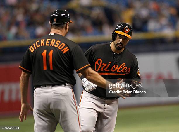Pedro Alvarez of the Baltimore Orioles celebrates with third base coach Bobby Dickerson hitting a home run off of pitcher Chris Archer of the Tampa...