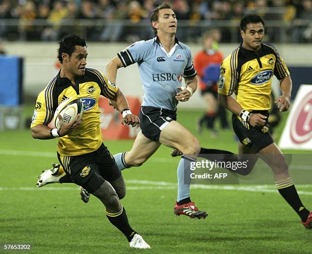 Wellington, NEW ZEALAND: Lome Fa'atau of the Hurricanes runs past Mat Rogers of the Waratahs to score a try during the Super 14 semi final match...