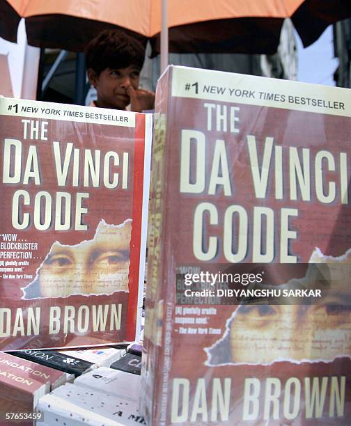 An Indian book vendor looks on as copies of 'The Da Vinci Code' are displayed on sale at his roadside book stall in Bangalore 19 May 2006. India's...