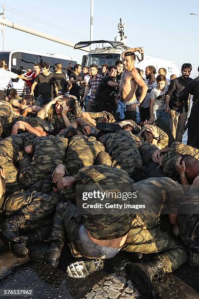 An unidentified man uses his belt to hit Turkish soldiers involved in the coup attempt that have now surrendered on Bosphorus bridge on July 16, 2016...