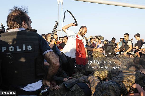 An unidentified man uses his belt to hit Turkish soldiers involved in the coup attempt that have now surrendered on Bosphorus bridge on July 16, 2016...