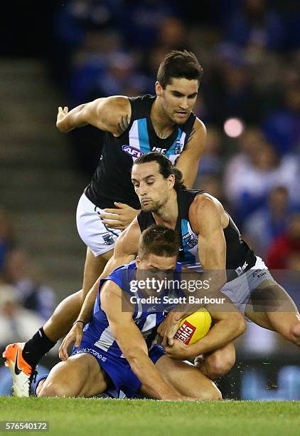 Andrew Swallow of the Kangaroos is tackled during the round 17 AFL match between the North Melbourne Kangaroos and the Port Adelaide Power at Etihad...