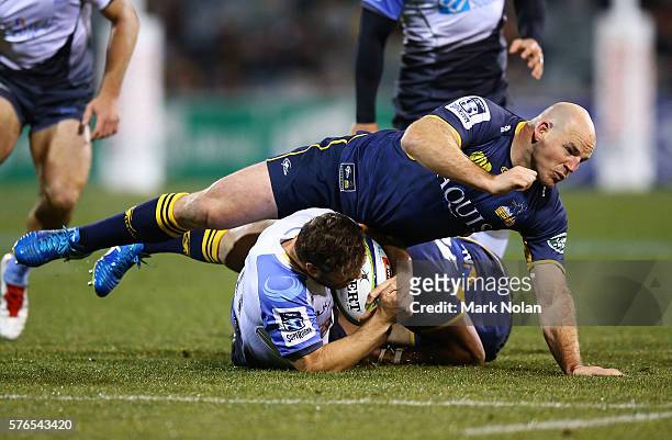 Stephen Moore of the Brumbies tackles Luke Morahan of the Force during the round 17 Super Rugby match between the Brumbies and the Force at GIO...