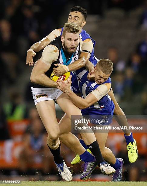 Jackson Trengove of the Power is tackled by Lindsay Thomas and Jed Anderson of the Kangaroos during the 2016 AFL Round 17 match between the North...