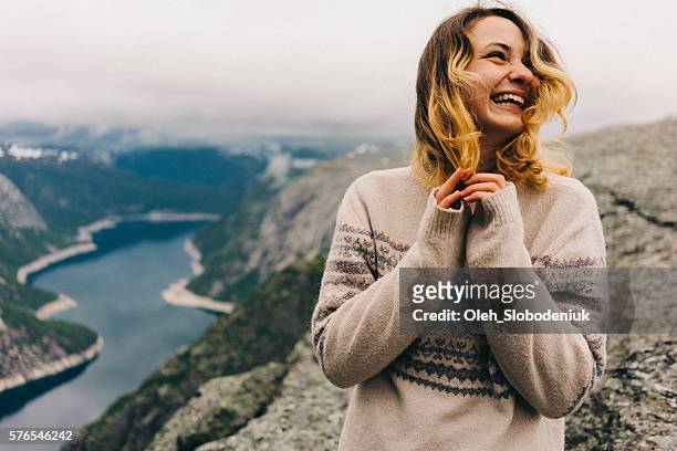 girl laughing on the trolltunga - queen sonja of norway stockfoto's en -beelden