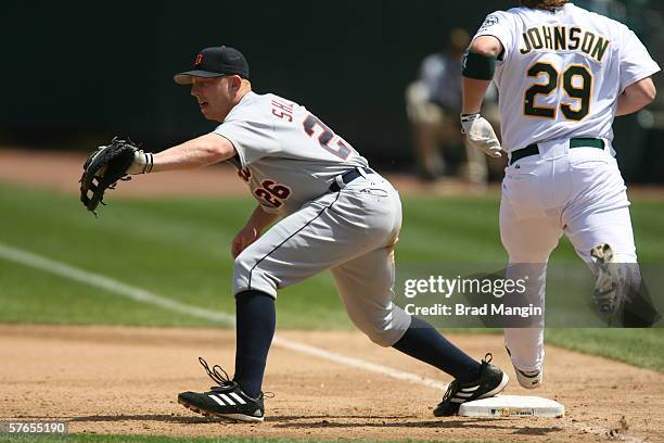 Chris Shelton of the Detroit Tigers fields as Dan Johnson runs during the game against the Oakland Athletics at the Network Associates Coliseum in...