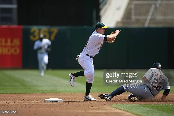 Mark Ellis of the Oakland Athletics fields as Chris Shelton slides during the game against the Detroit Tigers at the Network Associates Coliseum in...
