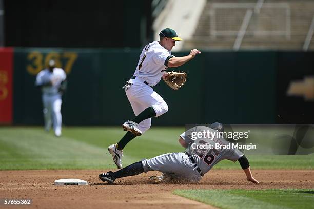 Mark Ellis of the Oakland Athletics leaps over a sliding Chris Shelton during the game against the Detroit Tigers at the Network Associates Coliseum...