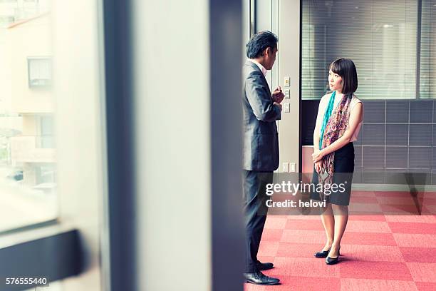 two business people yapanese ethnicity in conversation - free trade hall stock pictures, royalty-free photos & images