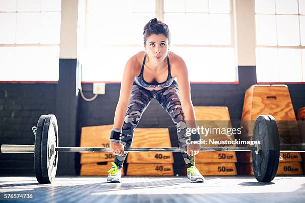 full length of young female dead lifting barbell in gym - chest stock pictures, royalty-free photos & images