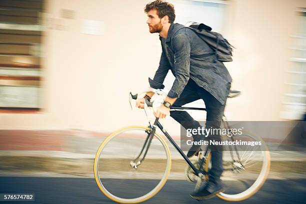 blurred motion of man riding bicycle - hipster guy stock pictures, royalty-free photos & images