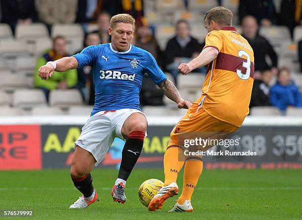 Martyn Waghorn of Rangers is tackled by Carl McHugh of Motherwell during the Scottish League Cup First Round Group Stage match between Motherwell FC...