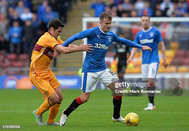 Andy Halliday of Rangers is tackled by Carl McHugh of Motherwell during the Scottish League Cup First Round Group Stage match between Motherwell FC...