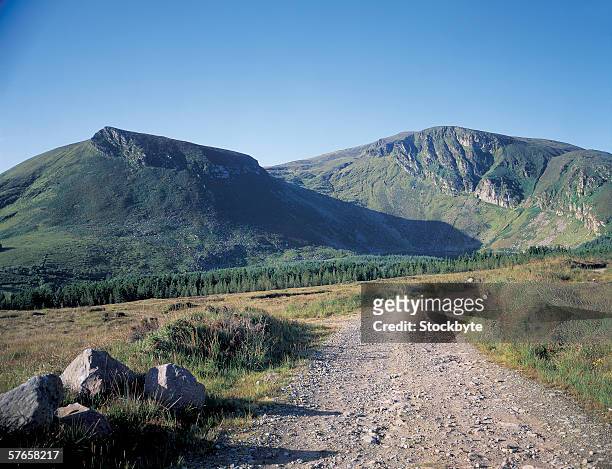 mountains and a pebbled pathway - pebbled road stock pictures, royalty-free photos & images
