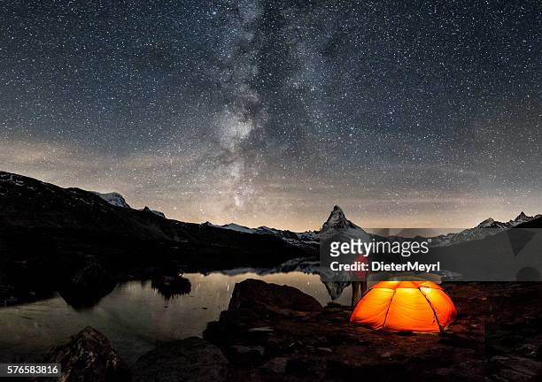 loneley camper under milky way at matterhorn - adventure stock pictures, royalty-free photos & images