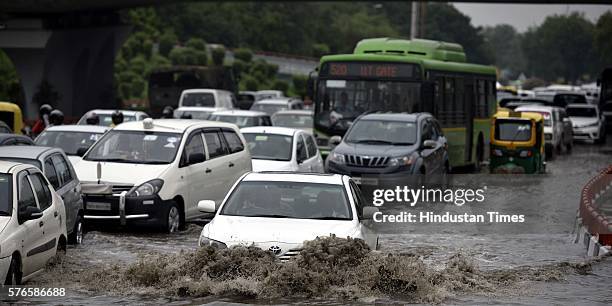 Vehicles wade through the water-logged road near AIIMS flyover after overnight rain, on July 16, 2016 in New Delhi, India. Overnight and morning rain...