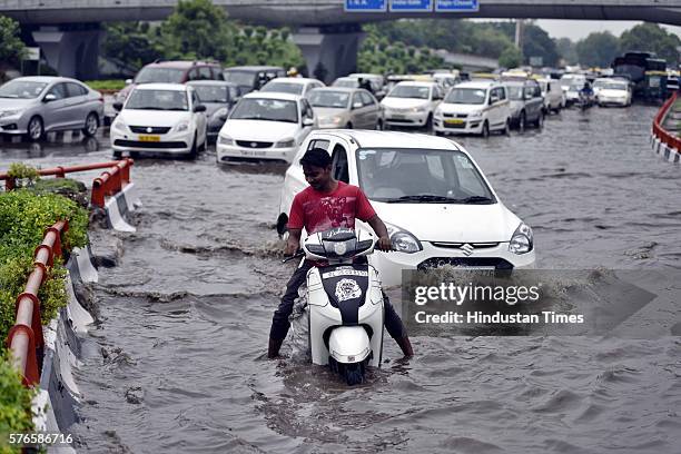 Vehicles wade through the water-logged road near AIIMS flyover after overnight rain, on July 16, 2016 in New Delhi, India. Overnight and morning rain...