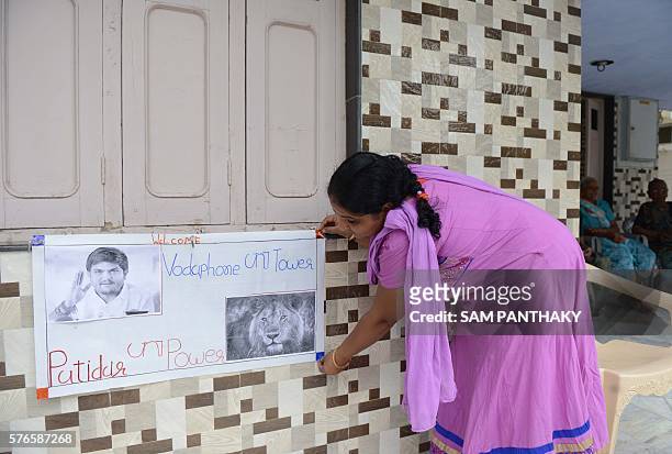An Indian relative arranges a poster bearing the image of Indian convenor of the Patidar Anamat Andolan Samiti movement Hardik Patel at Hardik's home...