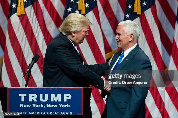 Republican presidential candidate Donald Trump shakes hands with his newly selected vice presidential running mate Mike Pence, governor of Indiana,...