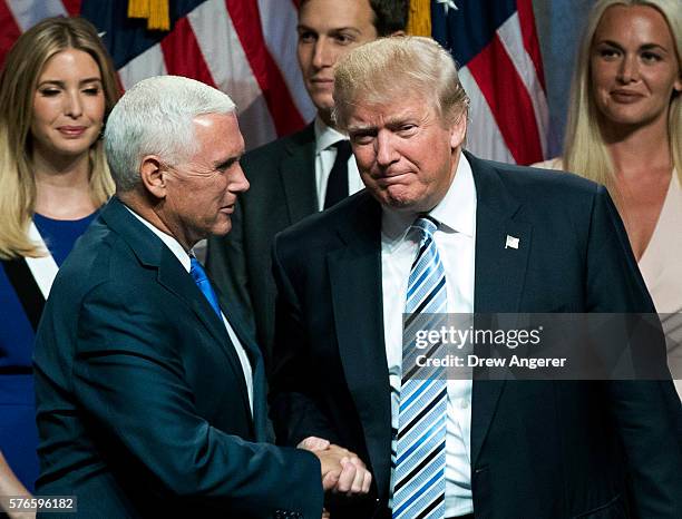 Newly selected vice presidential running mate Mike Pence, governor of Indiana, shakes hands with Republican presidential candidate Donald Trump at...