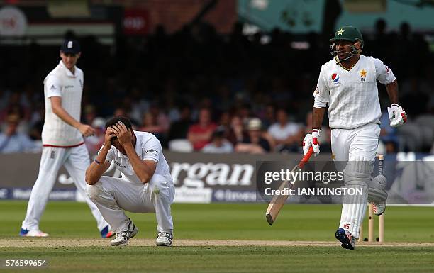 England's Steven Finn reacts after bowling a ball as Pakistan's Sarfraz Ahmed runs between the stumps on the third day of the first Test cricket...