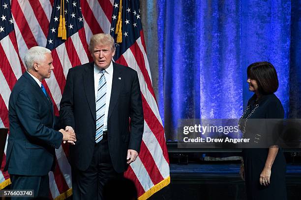 Republican presidential candidate Donald Trump stands with his newly selected vice presidential running mate Mike Pence , governor of Indiana, as...
