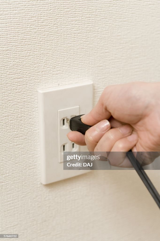 Putting Plug In Hand Placing Plug Into Electrical Outlet High-Res Stock Photo - Getty ...