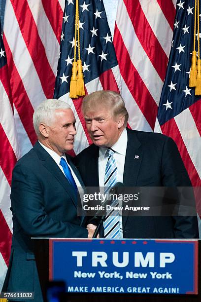 Newly selected vice presidential running mate Mike Pence, governor of Indiana, stands with Republican presidential candidate Donald Trump during an...