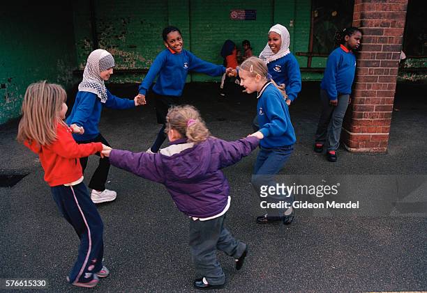 students playing ring-around-the-rosy on school playground - ring around the rosy stock pictures, royalty-free photos & images